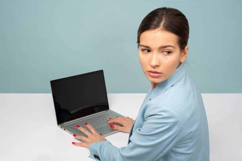 a woman in a blue suit holding a laptop.