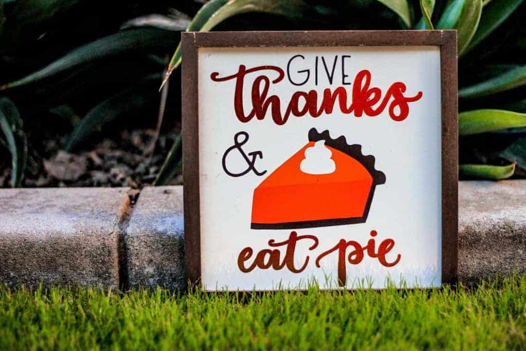Give Thanks and Eat Pie poster with brown frame on green grass field