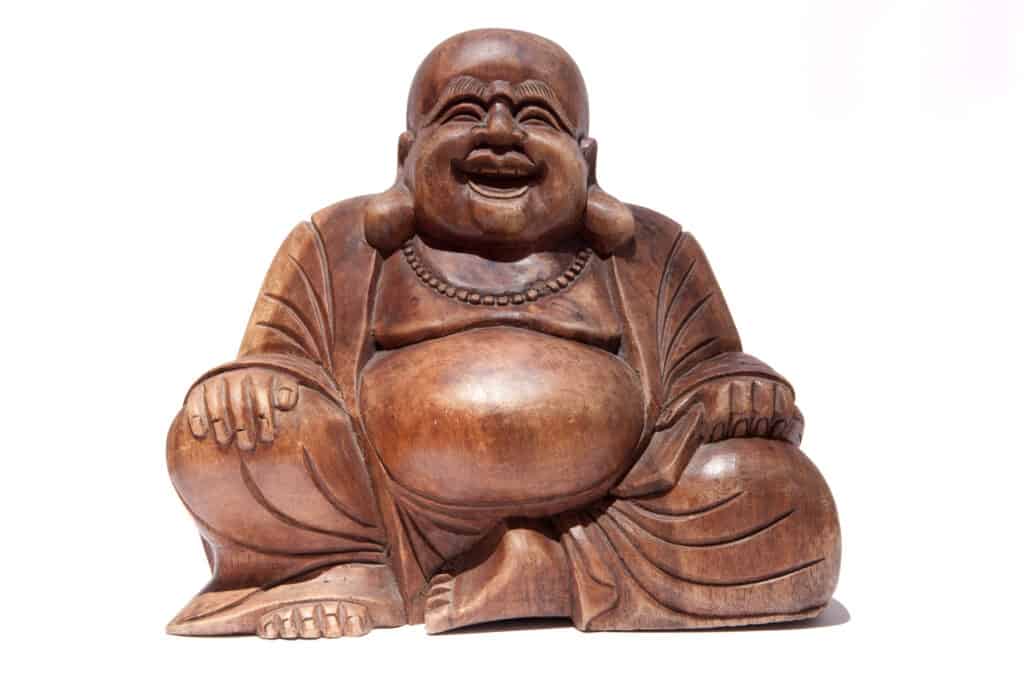 a wooden statue of a laughing buddha. 