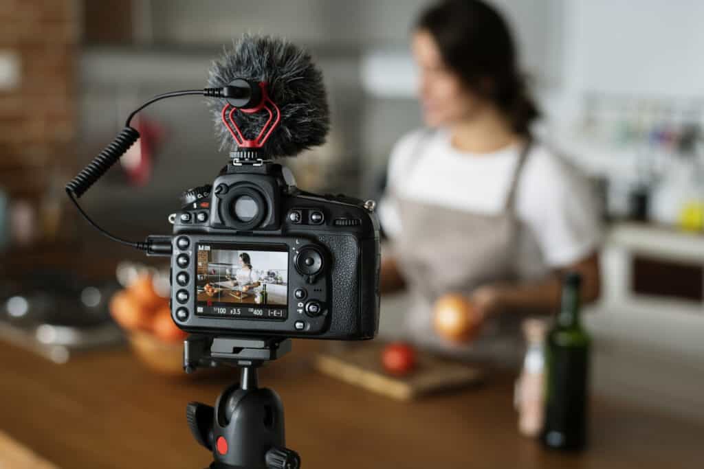 a woman is filming a video in the kitchen.