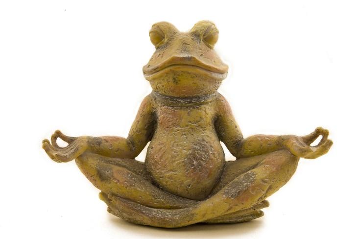 A statue of a frog sitting in a lotus pose.