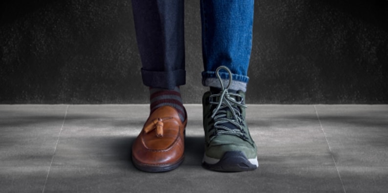A pair of men's feet standing on a black background.