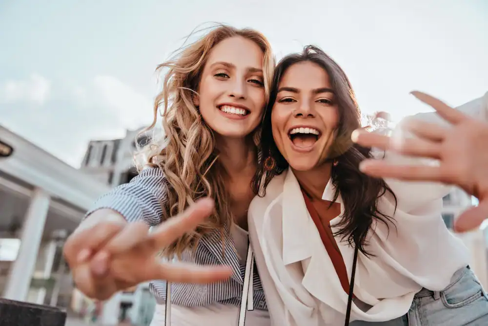 Pre-summer check in / Allison updates 4 Two young women smiling and flashing peace signs while posing closely together outdoors on a sunny day.